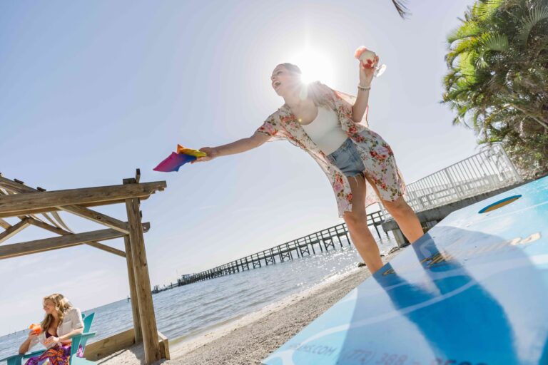 Woman drinking and having fun playing corn hole