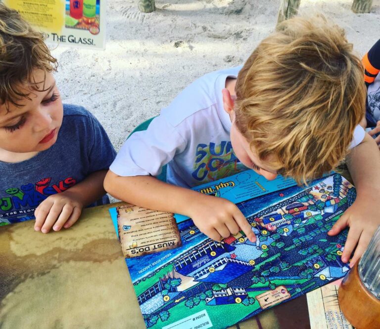 2 young boys looking at the map for Petey's scavenger hunt at Capt Hirams Resort