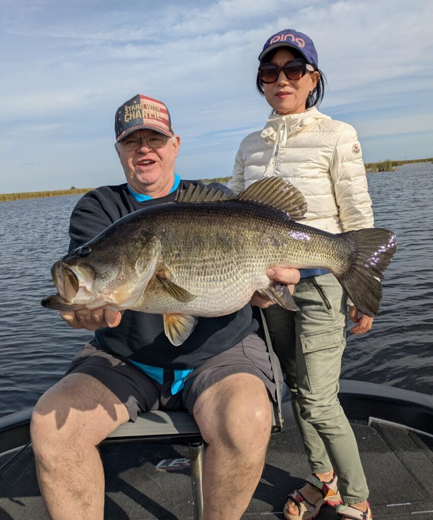 Man and woman with the large bass they caught fishing